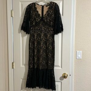Black lace dress lined with nude except the sleeves. The sleeves are 3/4 length